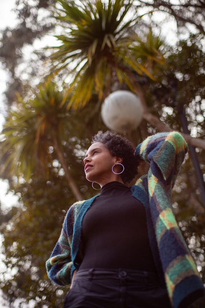 Fotografía de retrato de una mujer joven posando en un entorno exterior con fondo desenfocado (bokeh)
